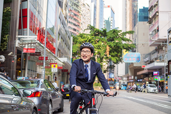Chinese man riding bike through city