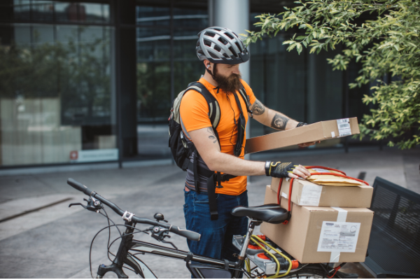 Male courier delivering parcels on bicycle
