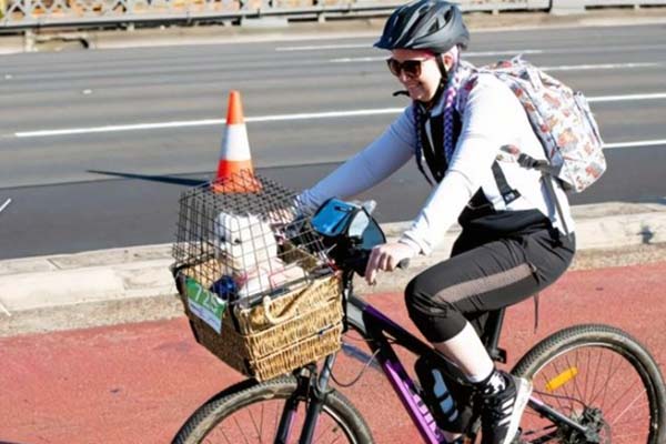 A rider carries a dog in a basket at the Spring Cycle in Sydney on Sunday. CREDIT: EDWINA PICKLES